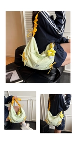 Detail view of mint green nylon tote with yellow drawstring and sunflower charm