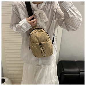 Detail of khaki nylon chest bag showing waterproof fabric texture and drawstring pocket