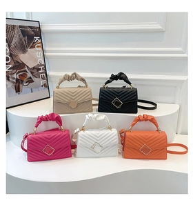 Macro shot of chevron quilted handbags with scrunched handles and square metal buckles