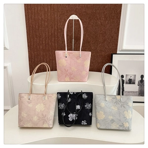 Detail view of large floral embroidery tote bags in pink, beige, black and blue colors