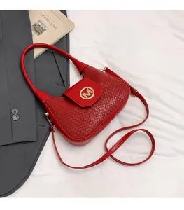Detalle de bolso hobo rojo trenzado con logo M dorado y correa de hombro ajustable