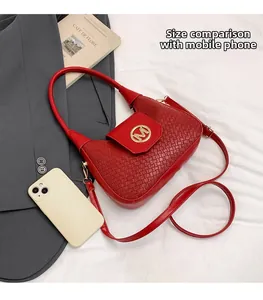 Detalle de la textura tejida del bolso rojo con hebilla dorada y comparación de tamaño