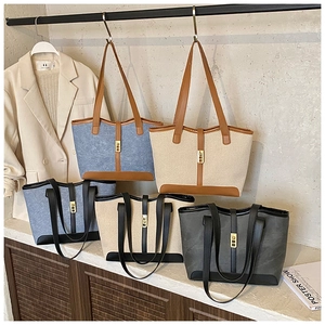 Detail view of large tote bags in mixed colors with metallic buckles and sturdy handles