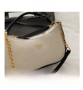 Detail of white lychee leather underarm bag with gold chain and Fashion Bags logo