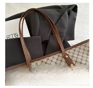 Close-up of vintage monogram fabric tote with leather trim and decorative metal rivets