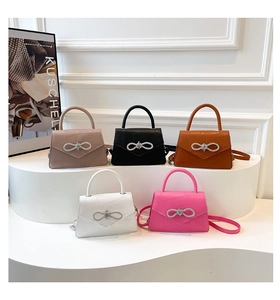 Detail of crocodile embossed crossbody bags in five colors with rhinestone bows