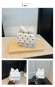 Detailed views of a white polka dot mini bag with an oversized bow and slim strap