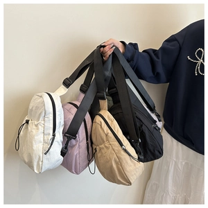 Detail view of nylon crossbody bags in multiple colors with adjustable shoulder straps