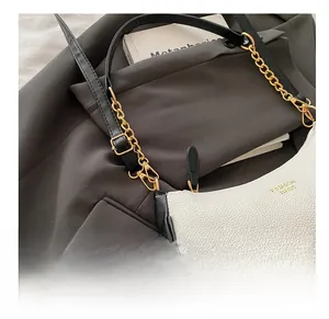 Close-up of contrast shoulder bag featuring lychee texture and golden hardware details
