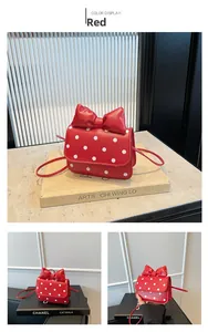 Detail of red mini crossbody bag with white polka dots and a large decorative bow