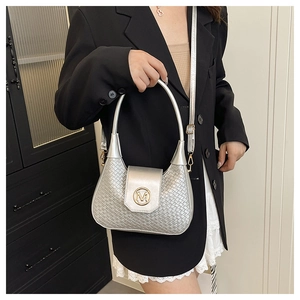 Detail of silver woven shoulder bag featuring a gold M logo and textured metallic finish