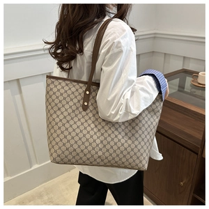 Close-up of vintage brown tote bag with geometric pattern and golden hardware details