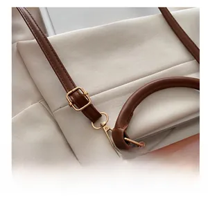 Detail of adjustable brown leather shoulder strap with gold-tone hardware and buckle