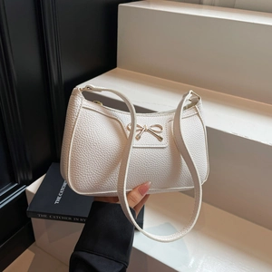 White pebbled leather hobo bag with a golden bow accent and zipper closure