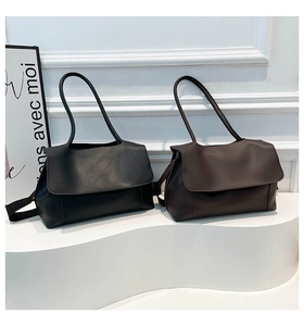 Macro display of minimalist black and dark brown leather tote bags on display pedestals
