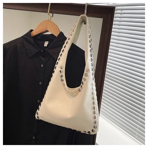 Detailed close-up of white PU leather hobo bag with silver metal rivet studs and handle