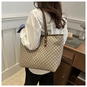Detailed back view of a large vintage monogram tote bag shown on a female model