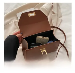 Detail view of brown rectangular handbag interior showing capacity for phone case and wallet