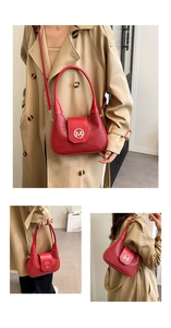 Detailed view of red woven underarm bag with gold M-logo buckle and dual shoulder straps
