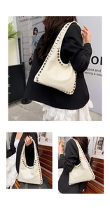 Detail of creamy white PU leather shoulder bag featuring silver metal rivets and stitching