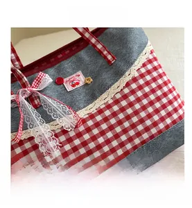 Detailansicht der Gingham-Stofftasche mit weißem Spitzenbesatz und Kirsch-Label