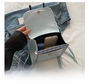 Detail view of mini shoulder bag interior showing capacity for phone and water bottle