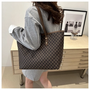 Lifestyle shot of woman wearing brown monogram tote bag with leather straps for daily commute
