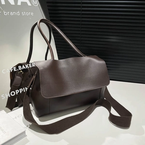 Minimalist deep brown large leather tote bag with wide knit shoulder strap shown from 45-degree angle