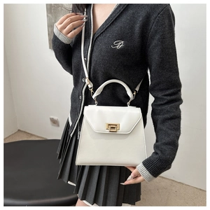 Minimalist white leather handbag with golden lock shown on model in stylish setting