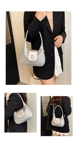 Detail of silver woven shoulder bag with golden M metal buckle and crescent moon shape