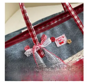 Detailansicht der Canvas-Tasche mit rotem Karomuster, Spitzenbesatz und Kirsch-Patch