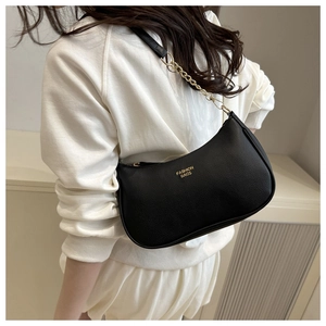 Detail of black crescent shoulder bag with lychee texture and gold metal chain strap