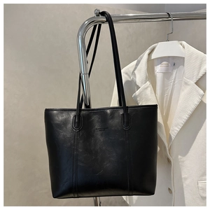 Dettaglio della borsa tote in pelle nera con scritta Fashion Bags impressa a rilievo