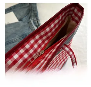Detailaufnahme des roten Reißverschlusses und Gingham-Futters der Tragetasche