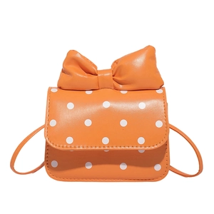 Mini orange polka dot crossbody bag for girls with a large bow and shoulder strap