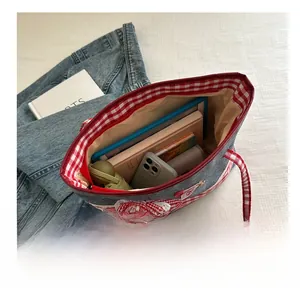 Geräumiger Innenraum der grauen Jeans-Tragetasche mit rot-blauem Karomuster Details