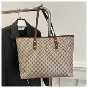 Detail view of retro geometric pattern tote bag on metal hanger with black suit blazer