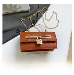 Braune Handtasche mit Krokodilprägung, Herzschloss und Handy-Größenvergleich