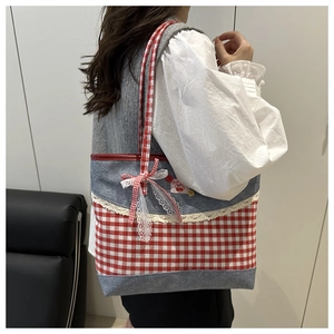 Detail der süßen Segeltuchtasche mit rotem Karomuster, Denim-Besatz und Spitzenschleife