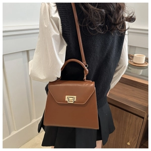Brown vintage leather crossbody bag with gold buckle shown in a lifestyle setting