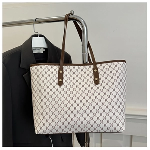 Detail of vintage geometric pattern and leather handle on a large canvas tote bag