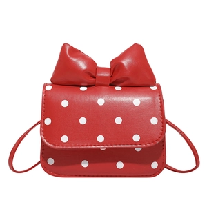 Polka dot mini shoulder bag with a large red padded bow and thin leather strap