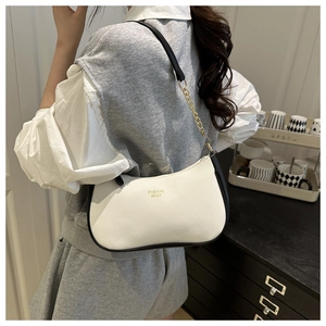 Detail of white lychee leather hobo bag with black trim and gold chain shoulder strap