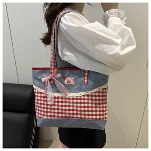 Détail du sac cabas à carreaux rouges avec dentelle, nœud et écusson cerise