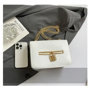 Detail of white crocodile pattern bag with gold chain strap and heart padlock hardware