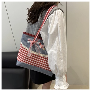 Detailaufnahme der Gingham-Canvas-Tasche mit Spitze, Schleife und Kirsch-Patch