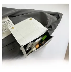 Detail view showing internal capacity of white crocodile pattern bag for smartphone