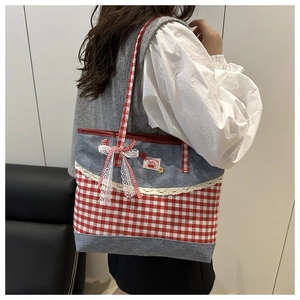 Détail du sac en toile à carreaux avec dentelle, empiècements denim et grand nœud rouge