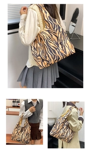 Detailopname van de stijlvolle tote bag met tijgerprint gecombineerd met diverse outfits