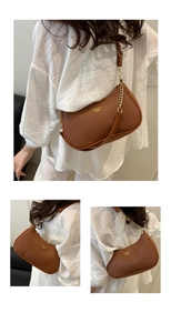 Detail of brown lychee texture armpit bag with metal chain strap and fashion text